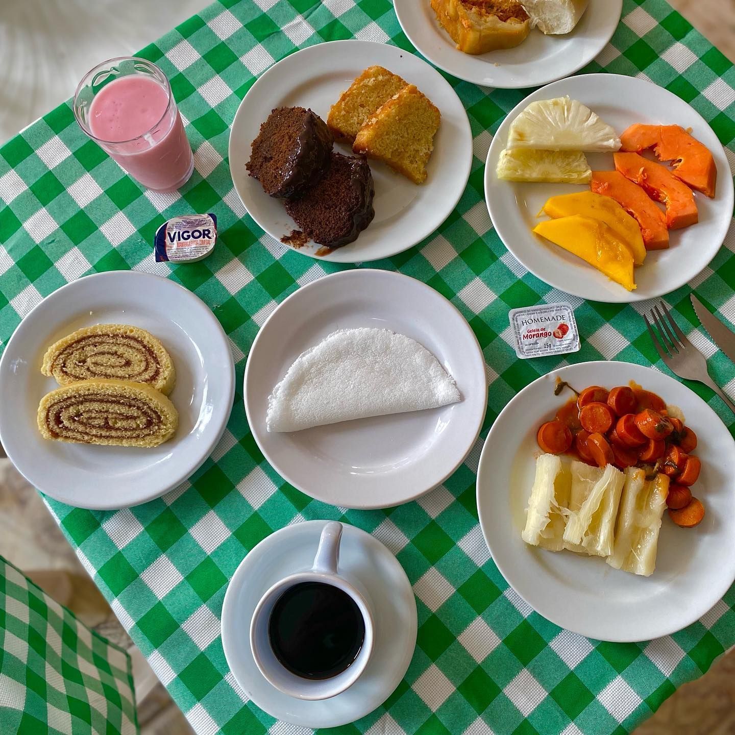 Uma mesa coberta com pratos de comida e uma xícara de café