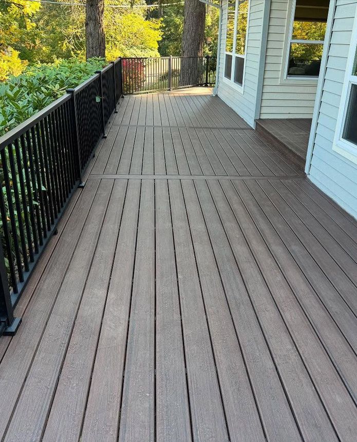 A wooden deck with a metal railing leading to a house