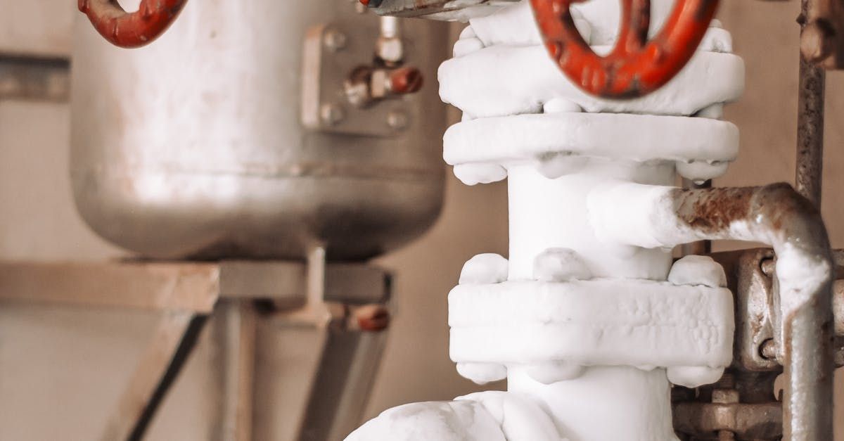 A close up of a white pipe with red handles.