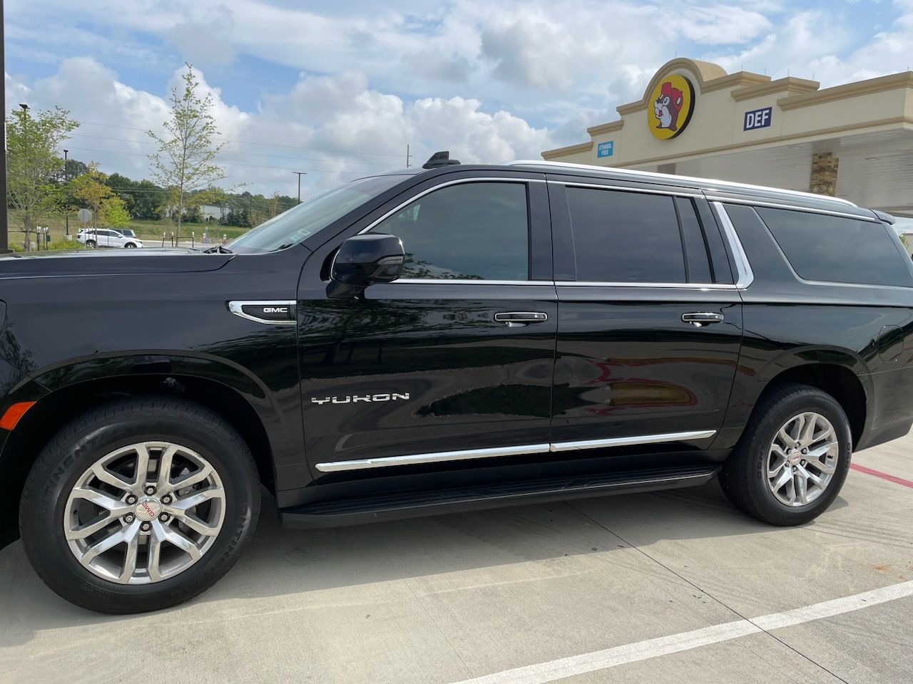 A black suv is parked in a parking lot in front of a building.