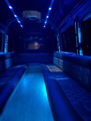 The inside of a shuttle bus is lit up with blue lights.