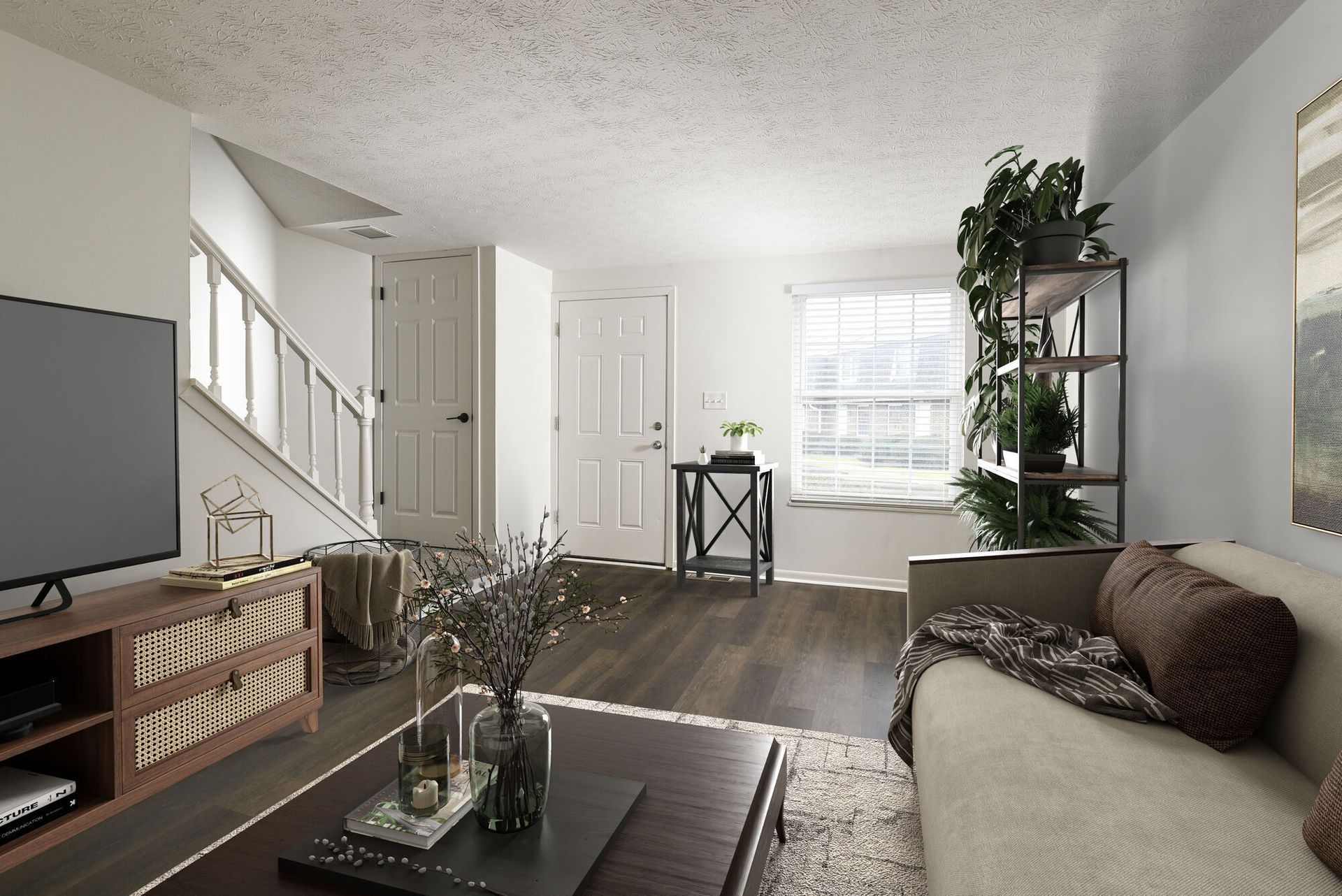 Living room in a modern apartment with sofa, coffee table, TV, stairs near a window.