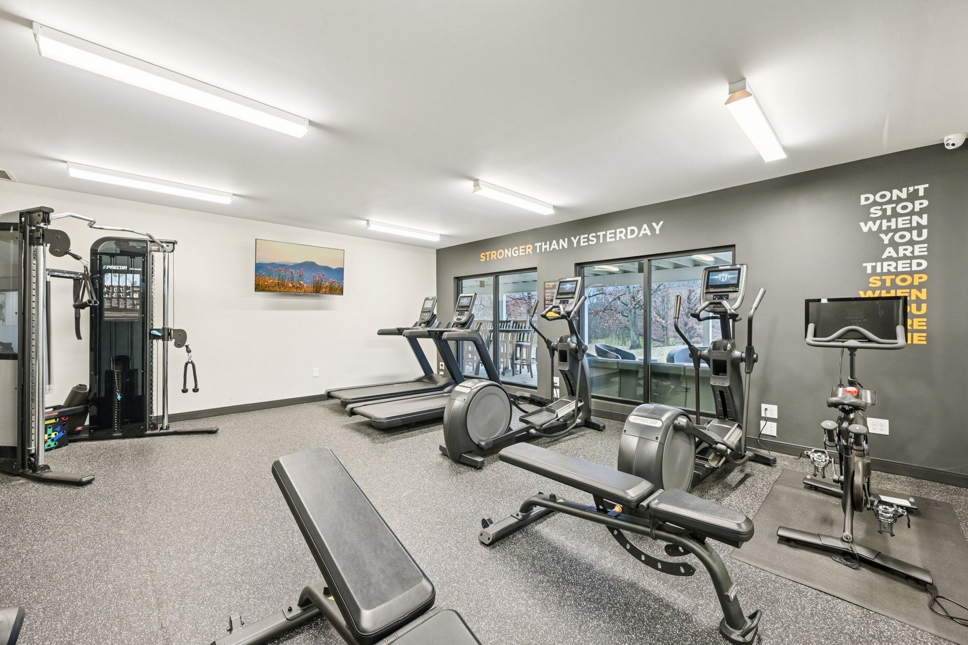 Bright indoor gym with treadmills, ellipticals, and weight machines in a modern facility.