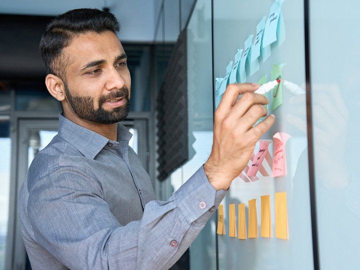 man writing on sticky notes