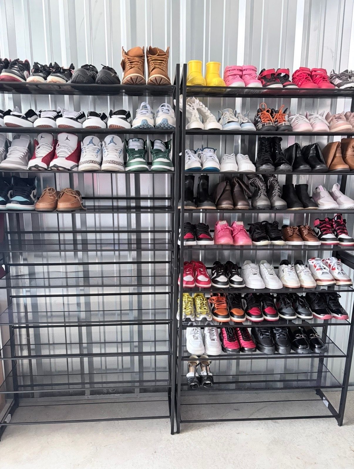 Shelves of neatly arranged shoes in a store or closet, with black, white, pink, and brown pairs.