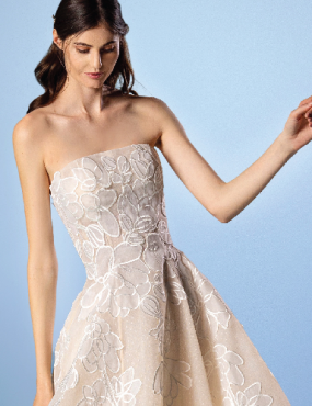 A woman is wearing a strapless white lace dress