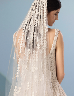 The back of a woman wearing a wedding dress and veil.