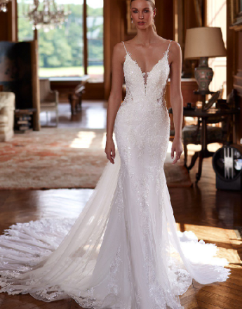 A woman in a white wedding dress is standing in a room.