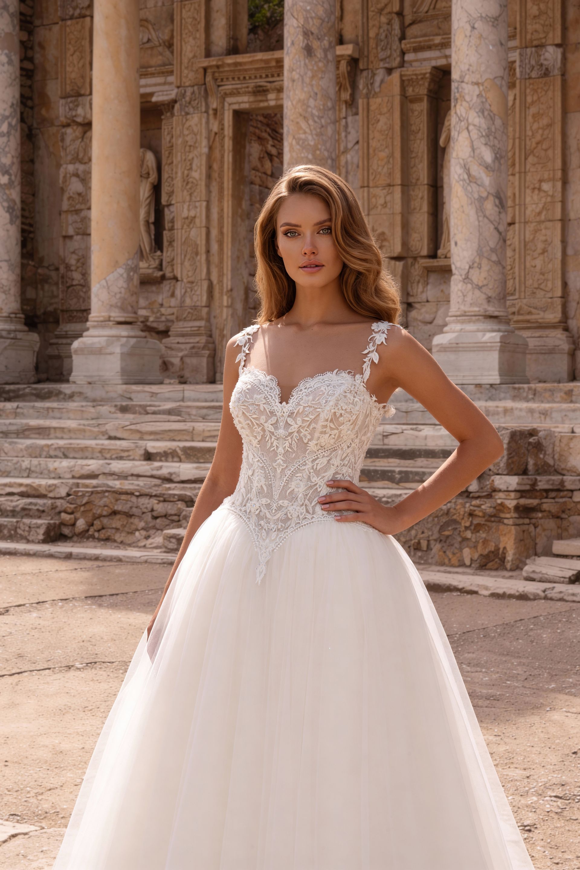Bride in a white lace wedding gown standing in ancient stone ruins.
