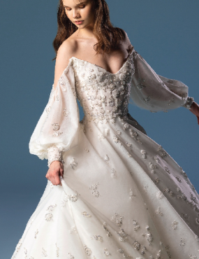 A woman is wearing a white wedding dress with balloon sleeves.