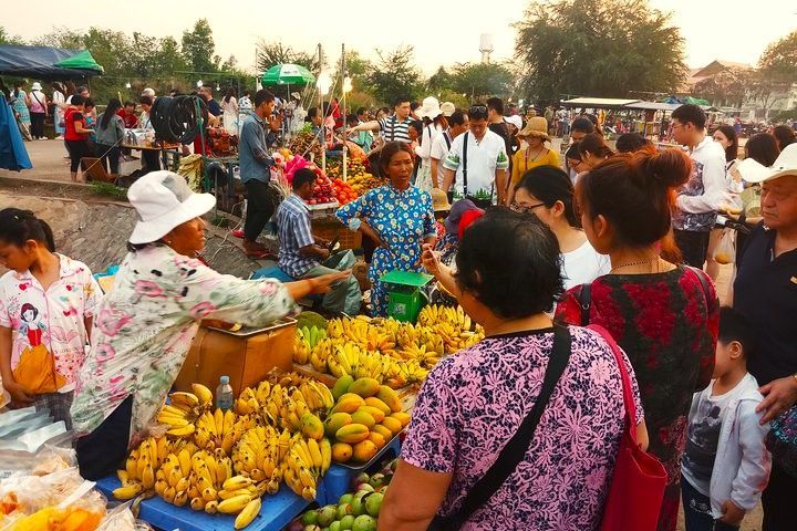 Private Siem Reap street food tour by tuk-tuk with local guide serving traditional Khmer dishes at night market stalls.