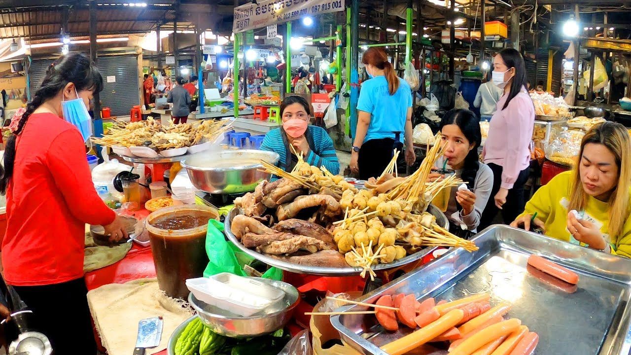 Private Siem Reap street food tour by tuk-tuk with local guide serving traditional Khmer dishes at night market stalls.
