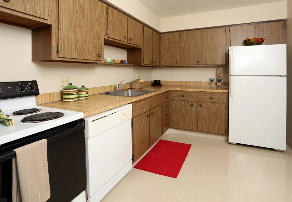 A kitchen with a stove , refrigerator , dishwasher , and sink.
