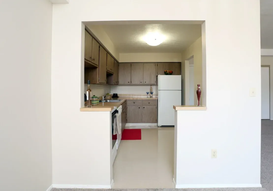 A kitchen with white cabinets and a white refrigerator