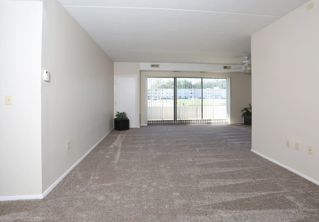 An empty living room with a sliding glass door