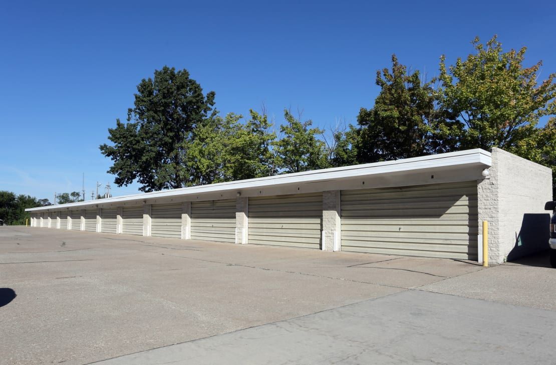A row of garage doors are lined up in a parking lot.