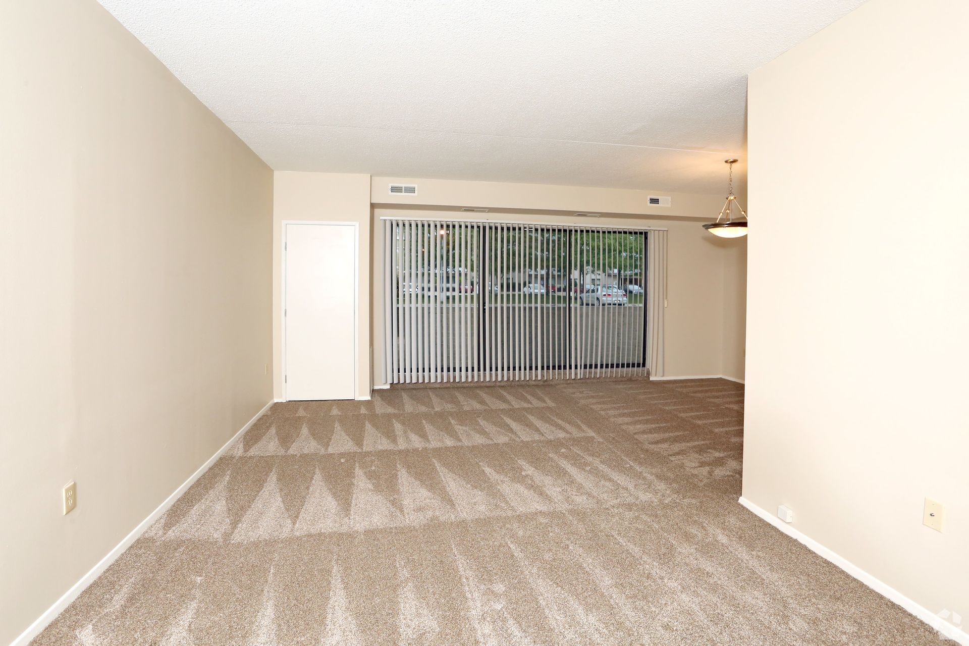 An empty living room with a sliding glass door
