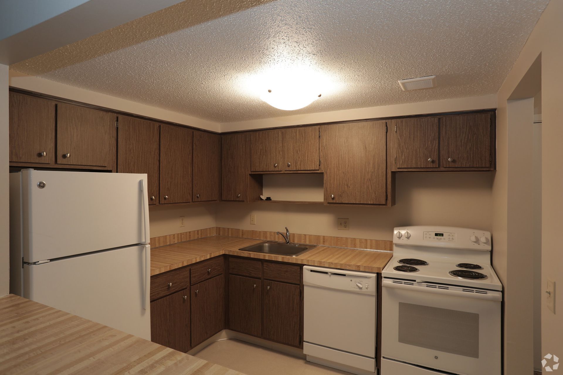 A kitchen with a refrigerator , stove , sink and dishwasher.