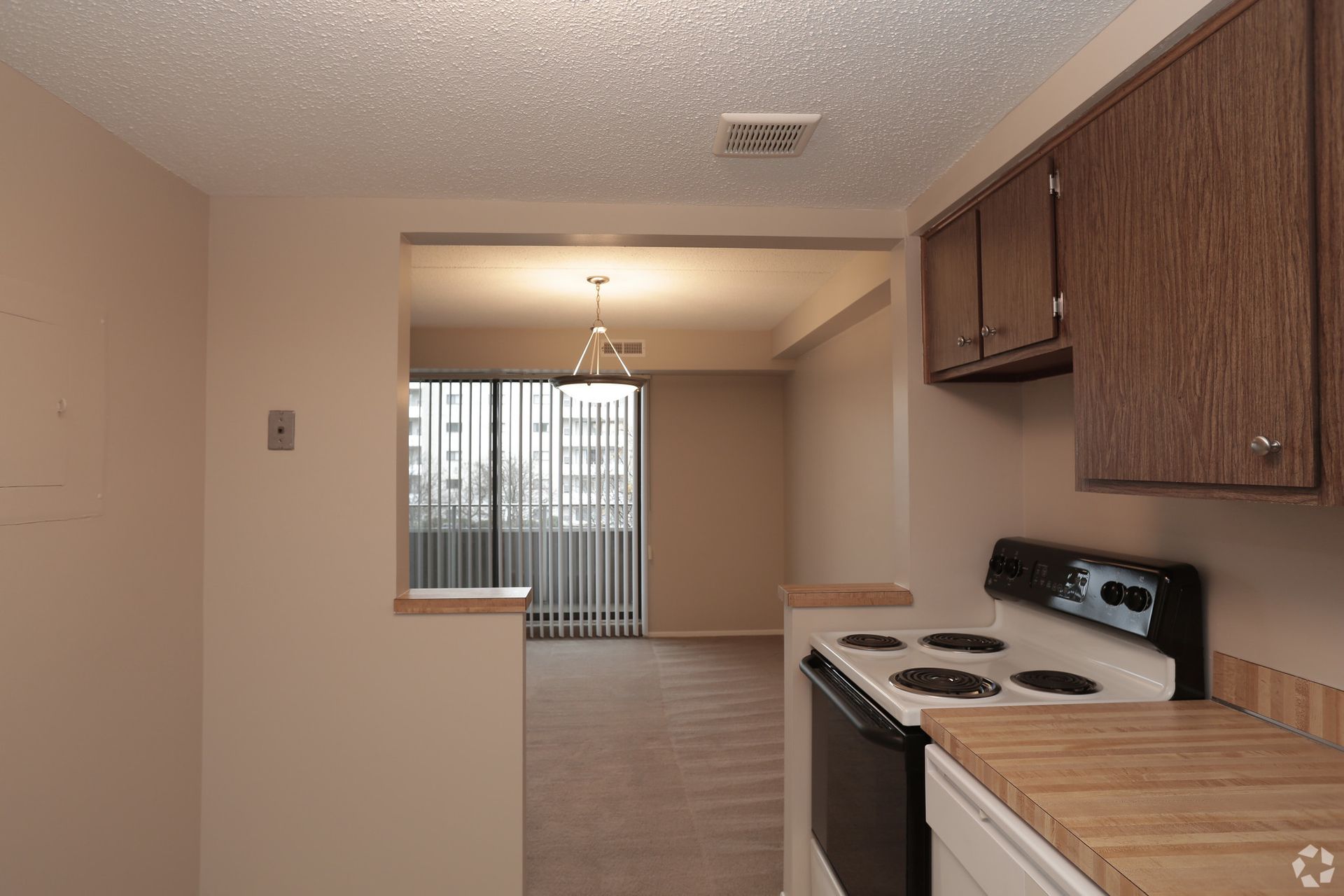 An empty kitchen with a stove , dishwasher , and cabinets.