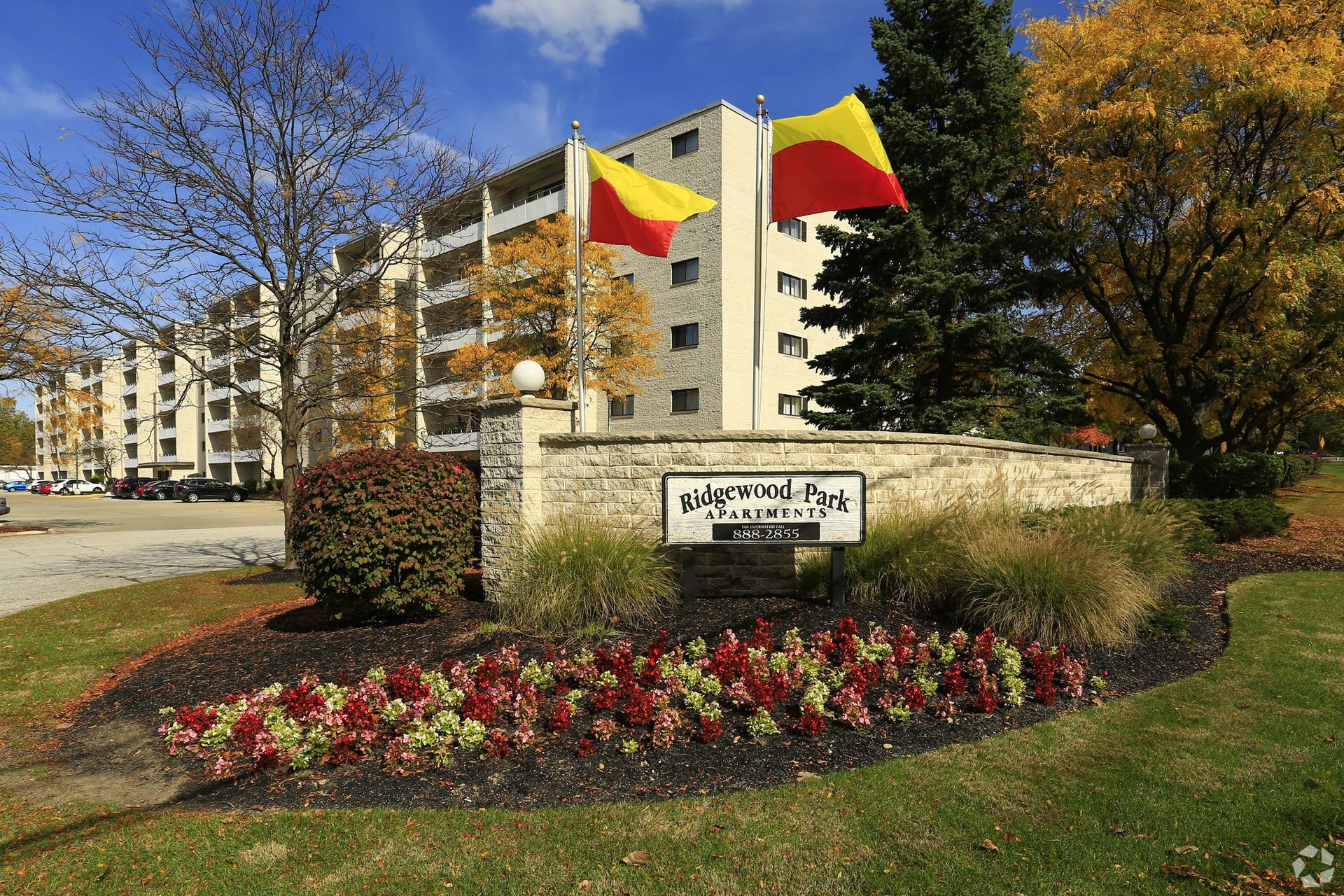A large apartment building with two flags flying in front of it.