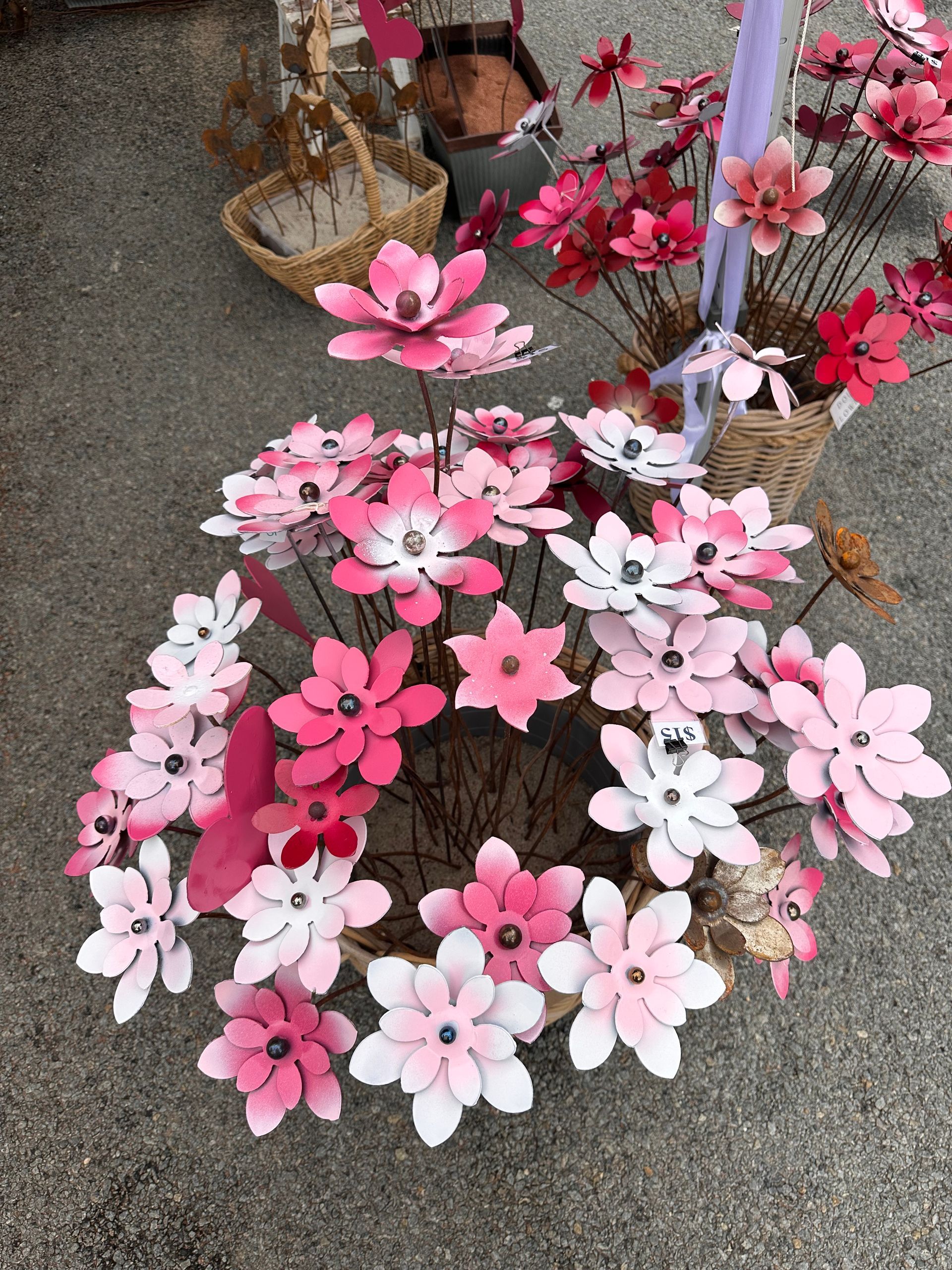 Pink and White Artificial Flower Wreaths Displayed on a Stand Outdoors — Professional Pool Builder in Wagga Wagga, NSW