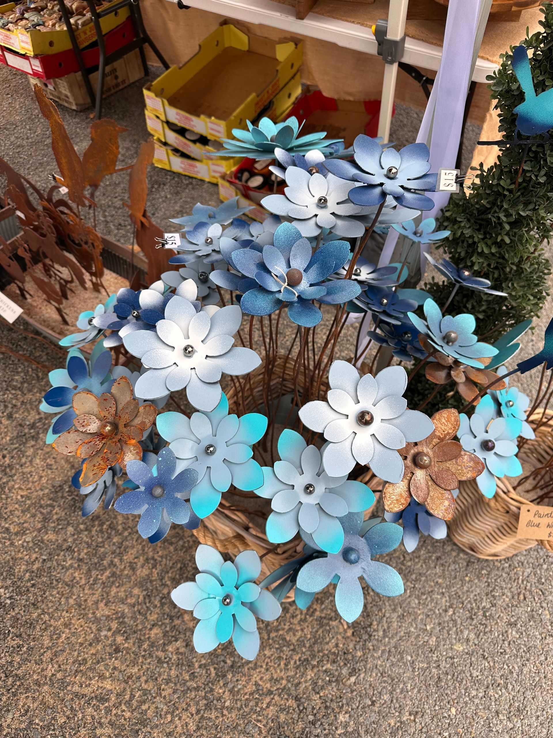 Pink and White Flower-shaped Pinwheel Wreaths Arranged on a Stand Outdoors — Professional Pool Builder in Wagga Wagga, NSW