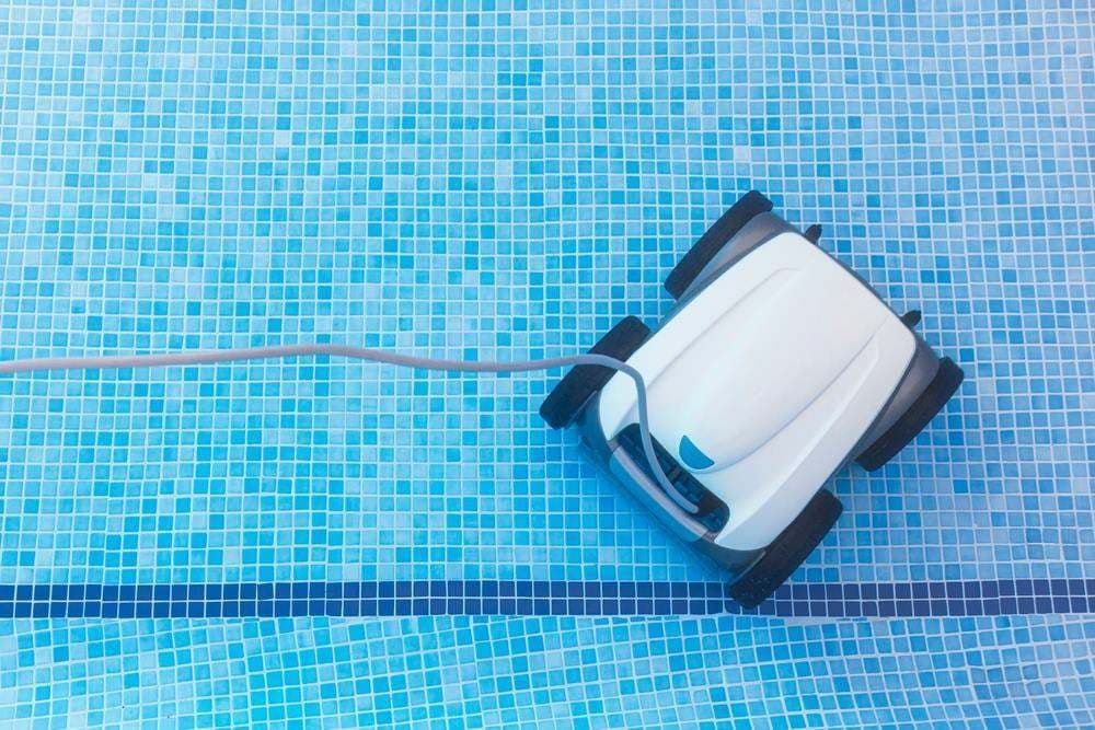 Robotic Pool Cleaner on Blue Tiled Pool Floor With Cord Trailing Behind — Professional Pool Builder in Wagga Wagga, NSW