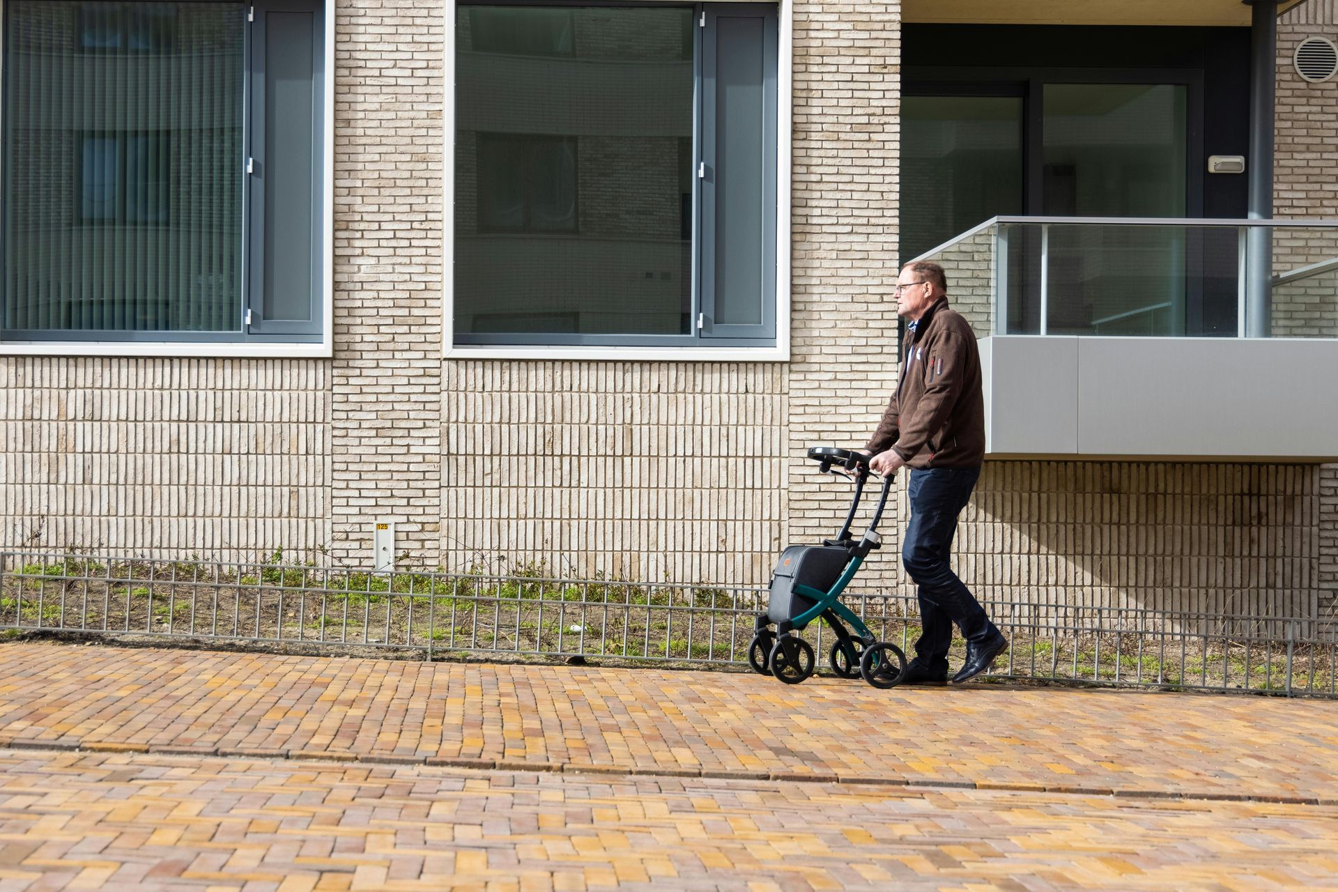 Rollator being utilized by a man while walking down the road