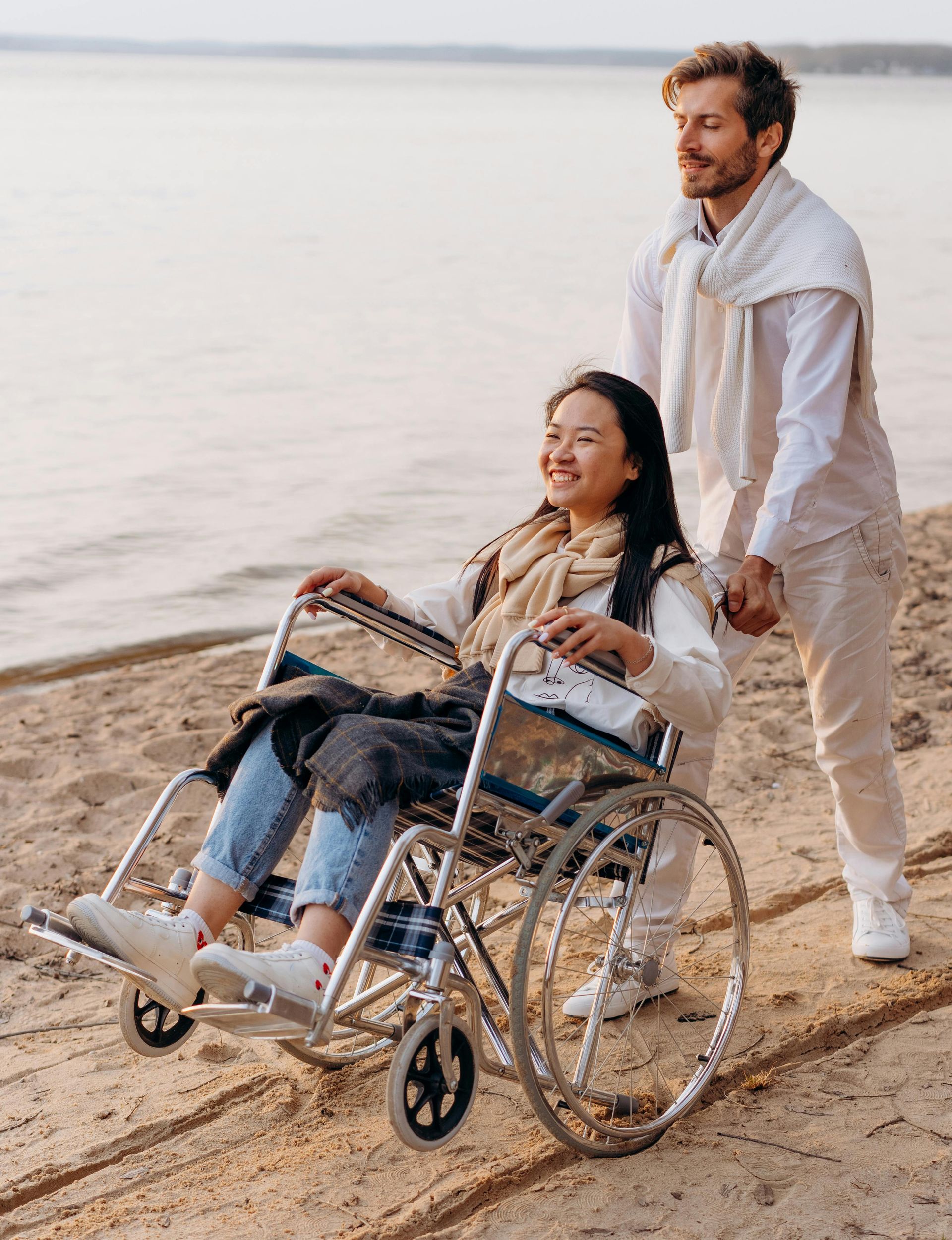 Couple utilizing a manual wheelchair on the beach