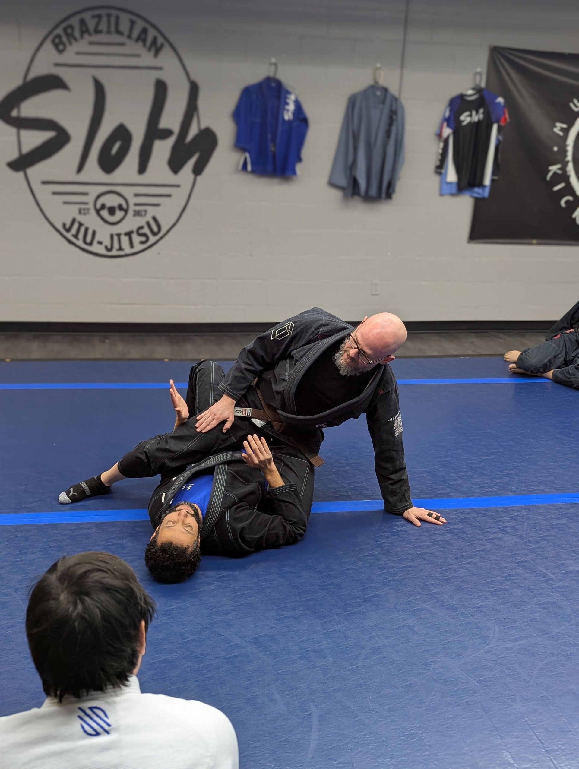 a man and a woman are wrestling on a mat in a gym .
