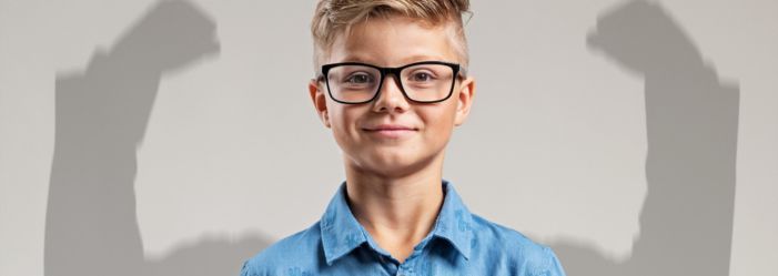 boy with glasses smiling with confidence