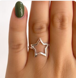 Mano con esmalte de uñas verde luciendo un anillo plateado en forma de estrella.