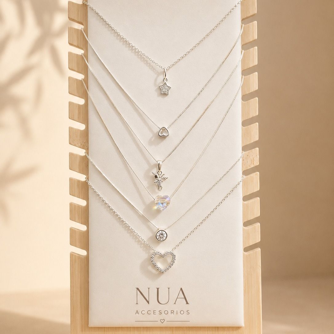 Collares de plata en forma de corazón superpuestos sobre una tarjeta blanca con la etiqueta 