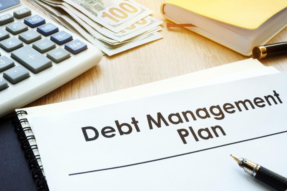 A Debt Management Plan Is Sitting on A Table Next to A Pen and Calculator — Sunshine Coast Financial Advisers in Caloundra, QLD