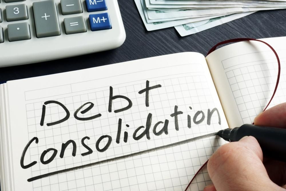 A Person Is Writing in A Notebook About Debt Consolidation — Sunshine Coast Financial Advisers in Noosa, QLD