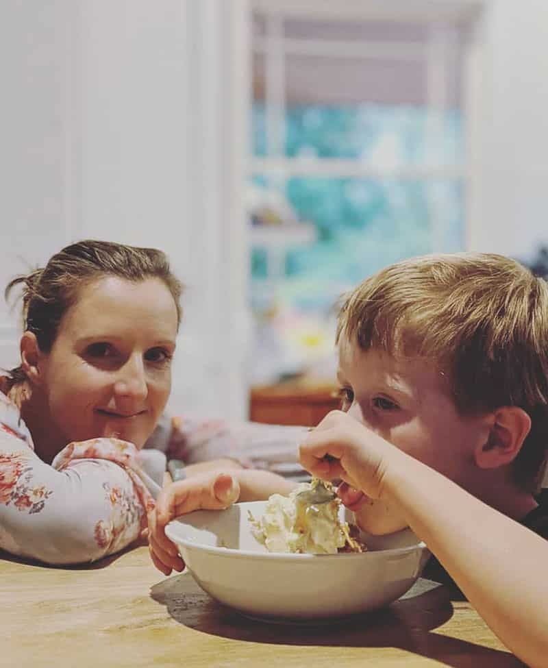 A Woman and A Boy Are Sitting at A Table Eating Food from A Bowl — Sunshine Coast Financial Advisers in Maroochydore, QLD