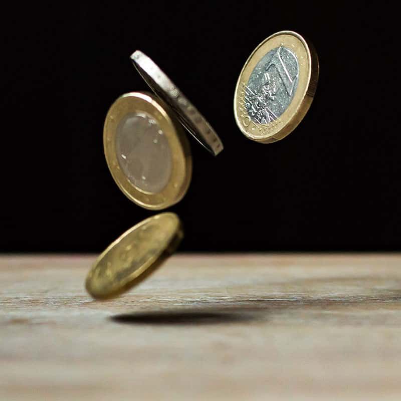 A Bunch of Coins Are Falling on A Wooden Table — Sunshine Coast Financial Advisers in Maroochydore, QLD
