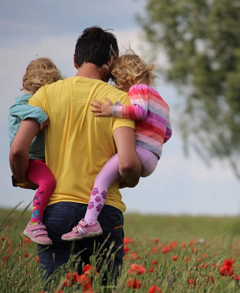 Father is Carrying Two Children in A Field of Flowers — Sunshine Coast Financial Advisers in Maroochydore, QLD