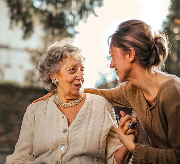A Young Woman Is Talking to An Older Woman in A Wheelchair — Sunshine Coast Financial Advisers in Maroochydore, QLD