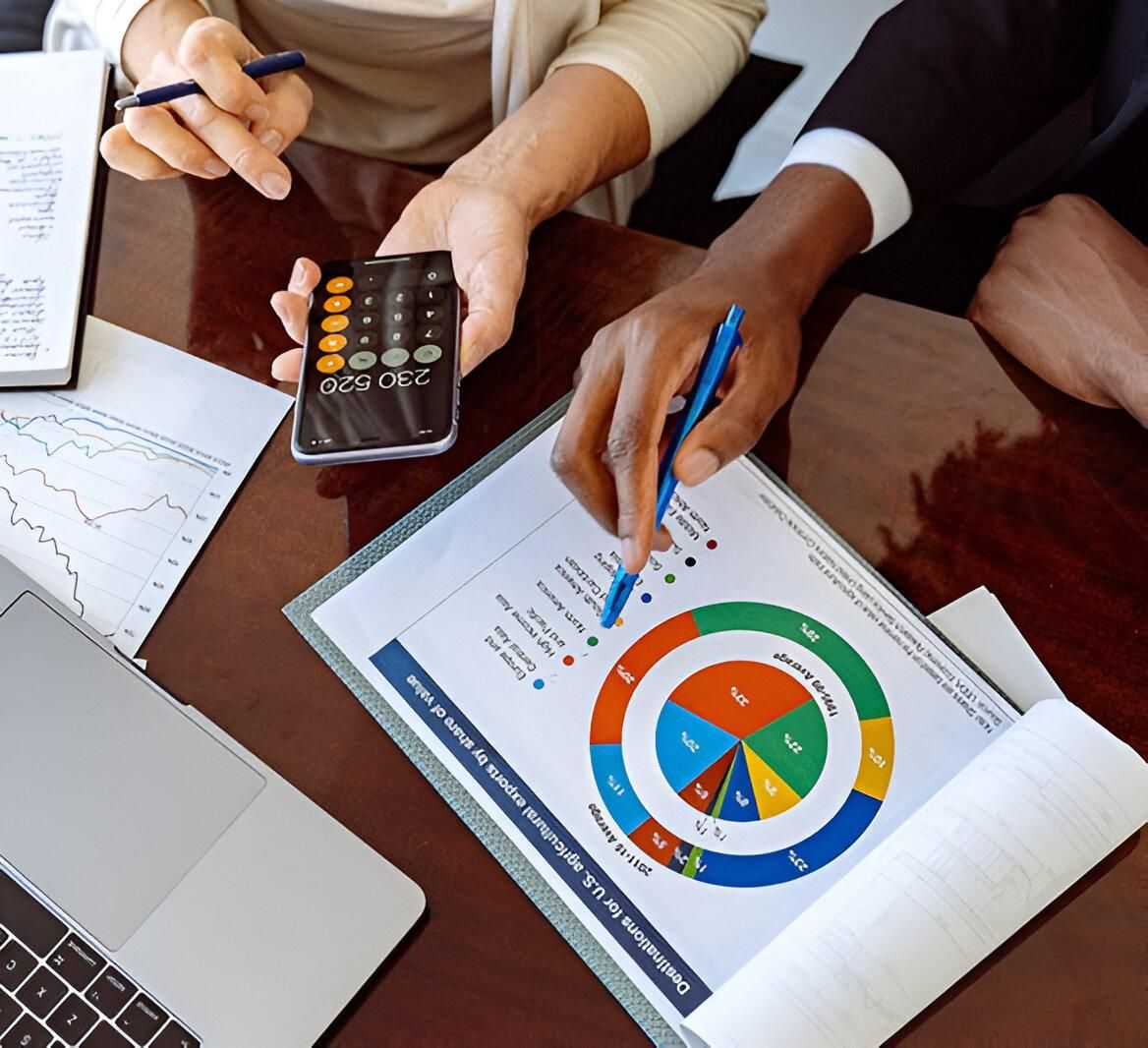 Two People Are Sitting at A Table Looking at A Pie Chart — Sunshine Coast Financial Advisers in Maroochydore, QLD