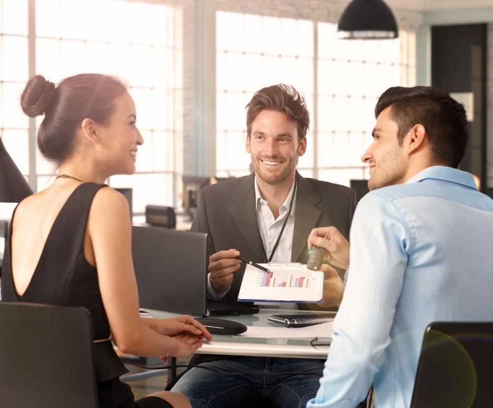 A Man and A Woman Are Sitting at A Table Talking to Each Other — Sunshine Coast Financial Advisers in Maroochydore, QLD