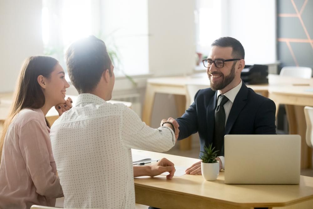 A Man and Woman Are Shaking Hands with A Man in A Suit and Tie — Sunshine Coast Financial Advisers in Maroochydore, QLD