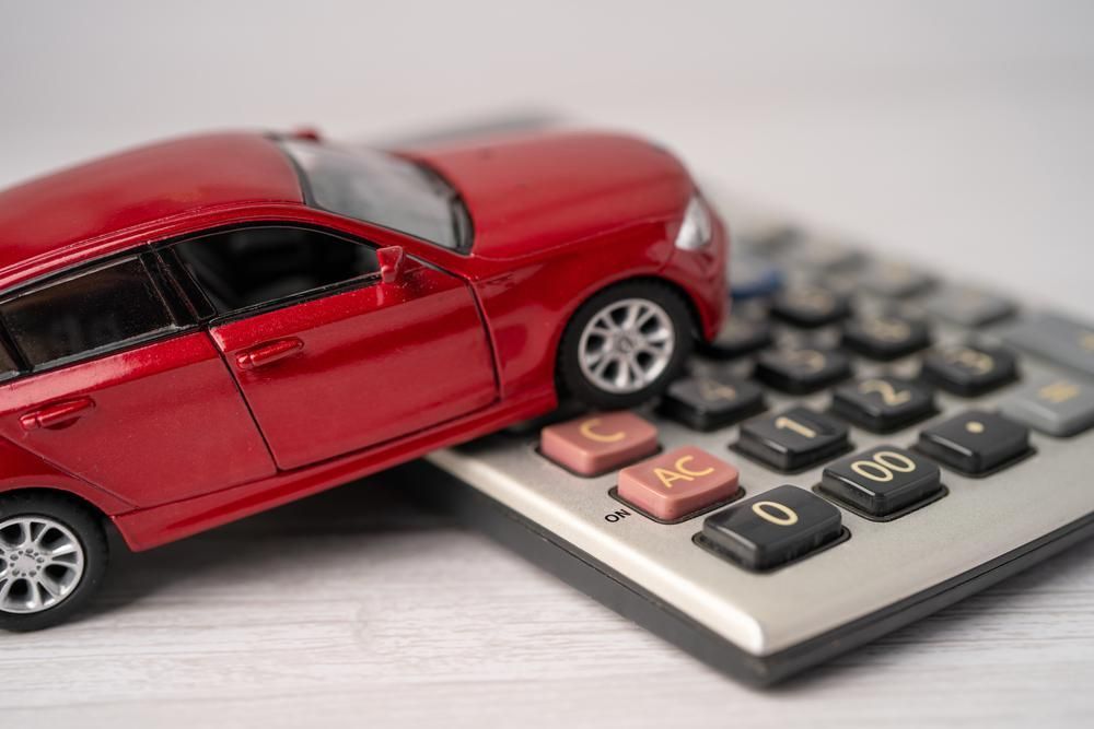 A Red Toy Car Is Sitting on Top of A Calculator — Sunshine Coast Financial Advisers in Maroochydore, QLD