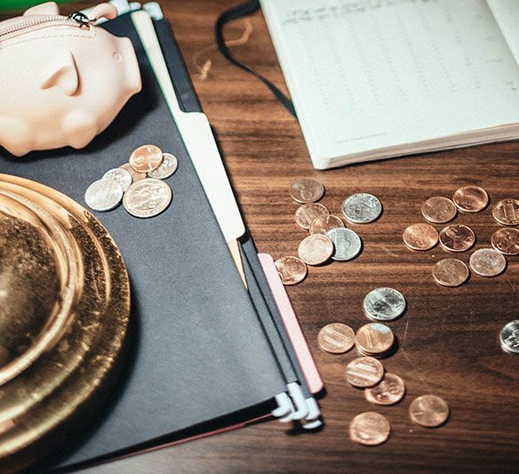 A Piggy Bank Sits on A Wooden Table Surrounded by Coins — Sunshine Coast Financial Advisers in Maroochydore, QLD