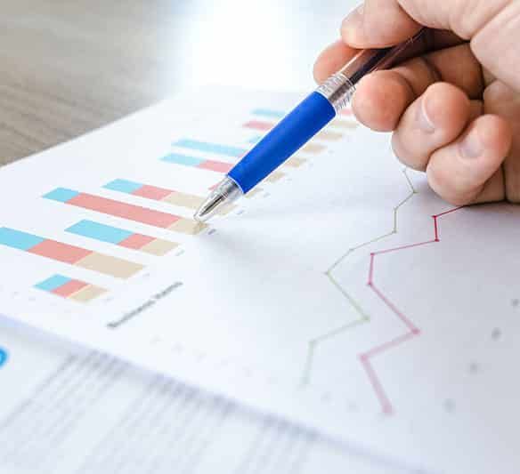 A Person Is Holding a Pen Over a Graph on A Piece of Paper — Sunshine Coast Financial Advisers in Maroochydore, QLD
