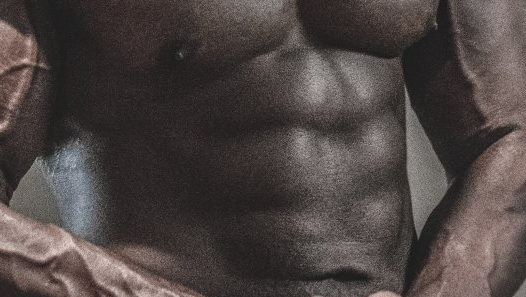 Close-up of a muscular torso with defined abdominal muscles and visible veins.