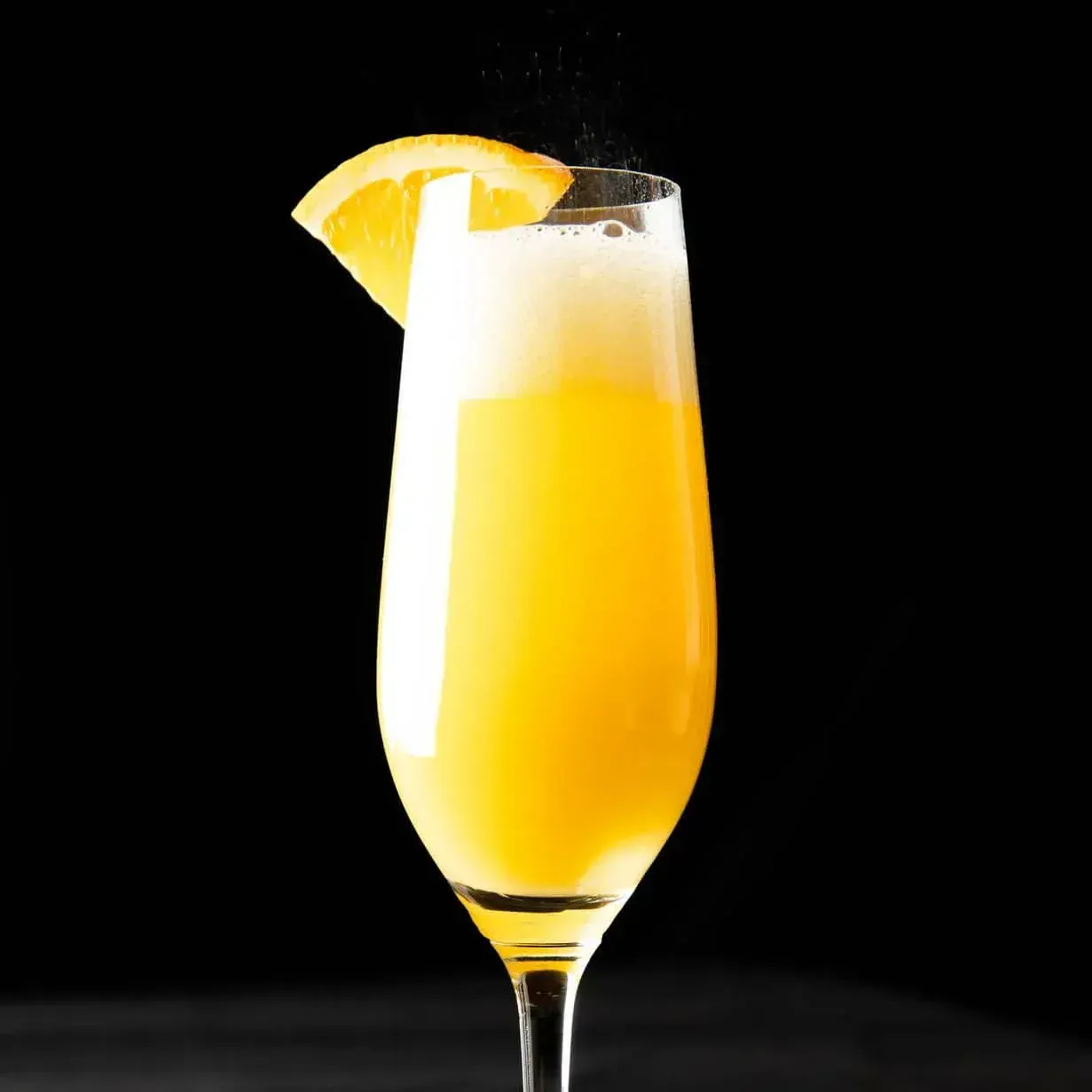 A glass of orange juice with a slice of orange on top