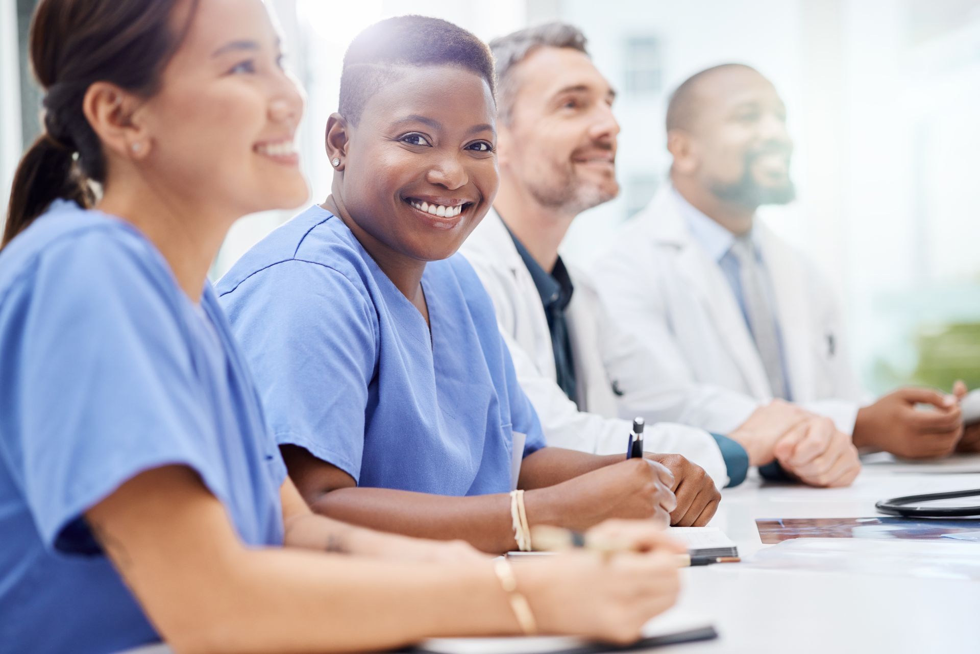 Life sciences professionals, smiling, at a meeting.