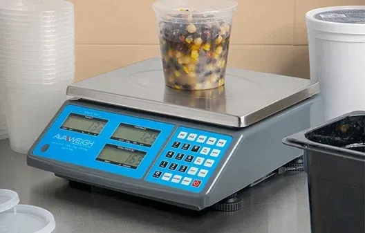 Digital food scale with a container of food on it, in a kitchen setting.