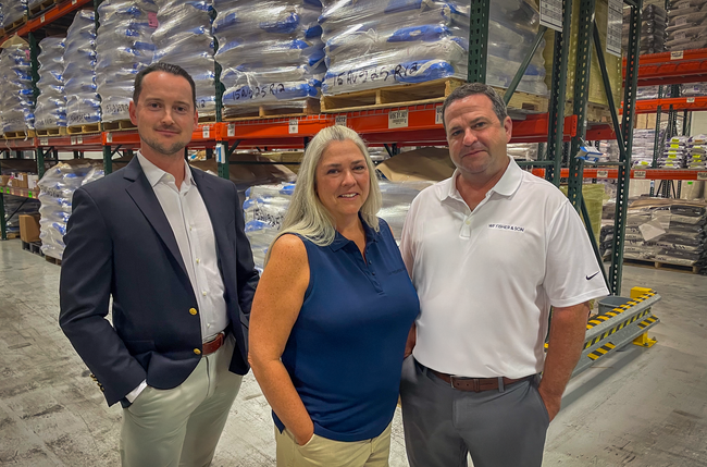 Colin Sabnie, Ann Falduto, and Joseph Bellomo standing in W.F. Fisher and Son’s warehouse among stocked inventory.